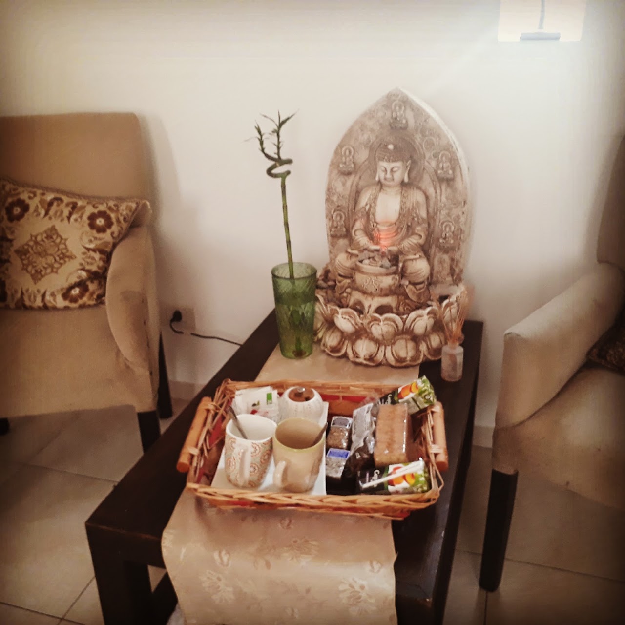 Sala de masajes principal en Spa Mandala's con camilla acolchada, velas encendidas, maderas cálidas y cuencos con piedras tibias